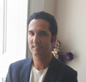 Carlos in a blazer by a window