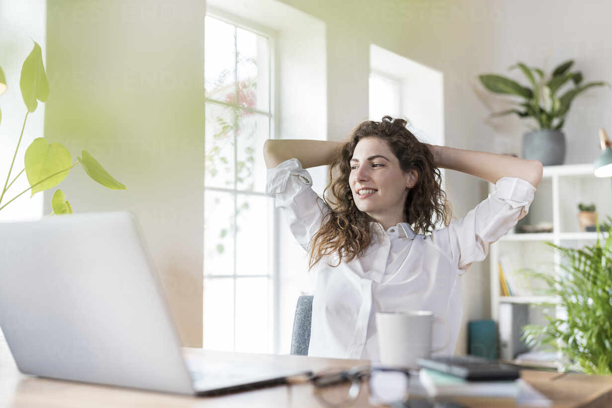 Smiling woman relaxing at her desk.
