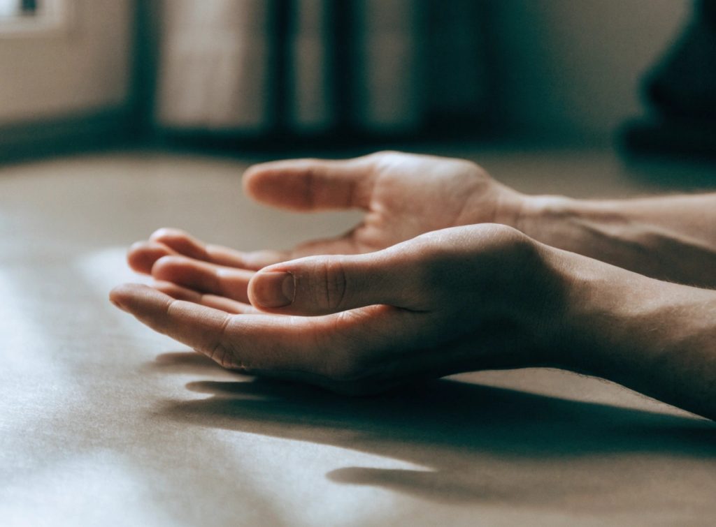 Open hands resting on floor in soft light
