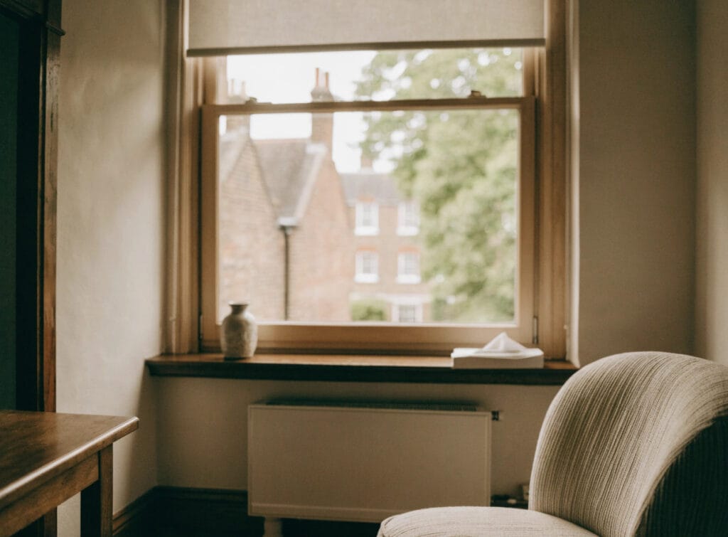 Cosy room with window overlooking brick houses